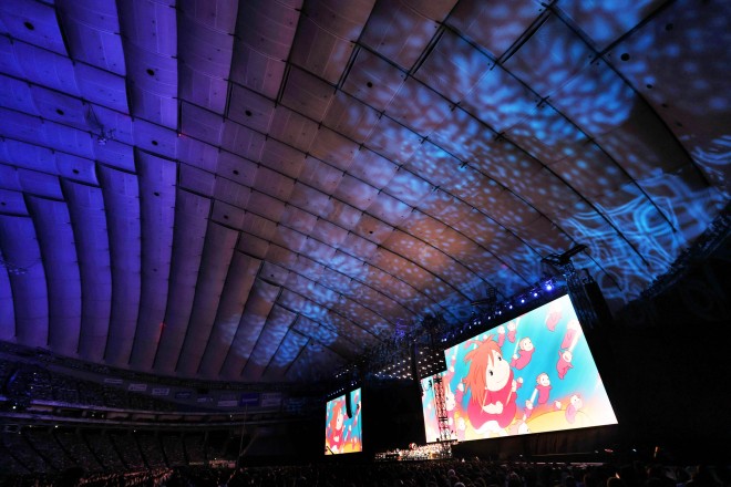 Joe Hisaishi conducts the Royal Philharmonic Orchestra at the Studio Ghibli Film Concert in Tokyo Dome.